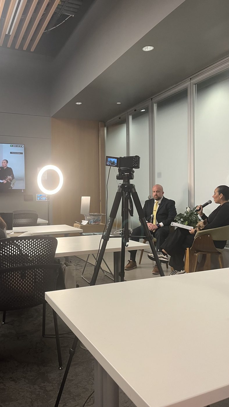 Professional interview filming setup with camera, tripod, and ring light at the training venue